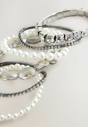 Käevõrude kollektsioon, mis sisaldab pärleid, selgeid kristalle ja metallaktsente hõbedases ja mustas, näidates erinevaid tekstuure ja disaine.