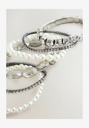 Kollektion von Armbändern mit Perlen, klaren Kristallen und Metallelementen in Silber und Schwarz, die unterschiedliche Texturen und Designs präsentieren.