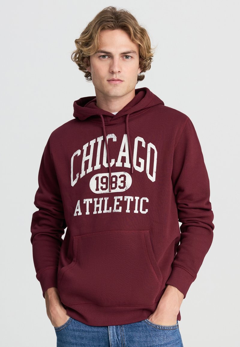Felpa maroon con tasca frontale, con il testo "CHICAGO 1983 ATHLETIC" in bianco. Tessuto morbido, cappuccio con coulisse e polsini a costine.