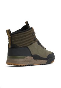 Hochformat-Stiefel aus olivgrünen Wildleder und schwarzem strukturiertem Material. Mit gepolstertem Kragen, grauen Akzenten und einer gesprenkelten braunen Gummisohle.
