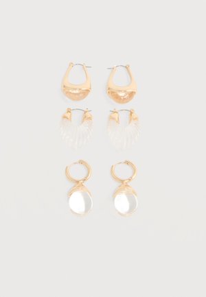 Kolm paari kuldse tooniga kõrvarõngaid, millel on läbipaistvad ja tekstureeritud akrüüldetailid, eksponeeritud vertikaalsetes ridades lihtsal heledal taustal.