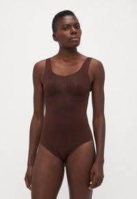 Brown one-piece swimsuit with wide straps, smooth texture, and a contoured front seam. Simple, form-fitting design without embellishments.