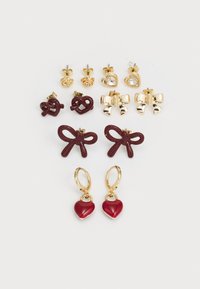 Set of earrings featuring gold and maroon accents, including heart shapes, bows, and various stud designs. Textured finishes enhance visual appeal.