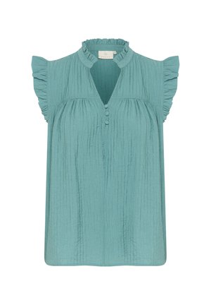Blouse turquoise avec un haut col froncé, des manches courtes flottantes et un tissu texturé. Présente une patte de boutonnage partielle à l'avant.