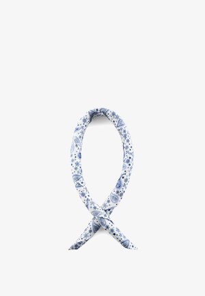 Blått og hvitt paisleymønstret stoff tvunnet til en løs løkke på hvit bakgrunn.