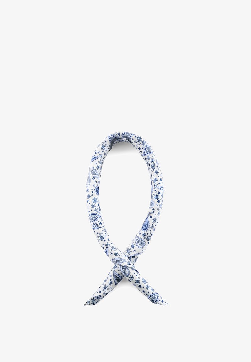 Blått og hvitt paisleymønstret stoff tvunnet til en løs løkke på hvit bakgrunn.