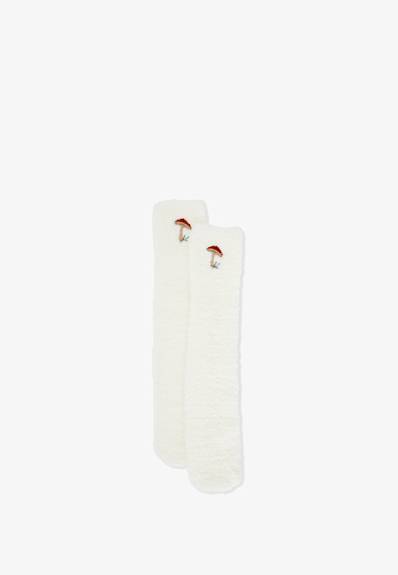 Cremefarbene, flauschige Stulpen mit bestickten Designs von roten Fliegenpilzen. Weicher Stoff und verlängerte Form für zusätzlichen Schutz und Wärme.