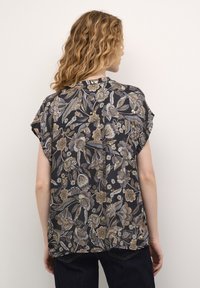 Trumpas rankovėmis palaidinė su tamsiu gėlių raštu auksinėmis, kreminėmis ir mėlynomis spalvomis. Pagaminta iš lengvos medžiagos; laisvo silueto su nugaroje esančia klostė.