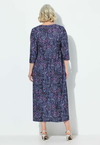 Vestido maxi en tejido estampado con fondo azul marino, diseño paisley en púrpura y azul, y mangas tres cuartos. Cintura acentuada.