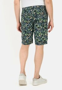 Herren Shorts in dunkelblauem Grund mit einem tropischen Blattmuster in Grün und Beige. Hergestellt aus leichtem Stoff, mit seitlichen Taschen.