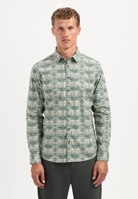 Groen gestippeld overhemd met een geometrisch ontwerp in verschillende tinten groen en roomkleur. Lange mouwen en een standaardkraag.