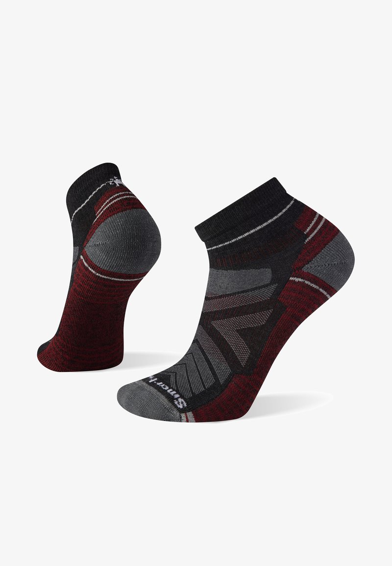 Meias atléticas curtas em preto, cinza e bordô. Apresentam um design de tornozelo com padrões texturizados e áreas reforçadas para durabilidade.
