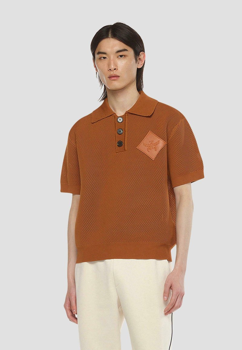 Braunmesch-Poloshirt mit strukturiertem Muster, drei Knöpfen und einem rhombusförmigen Logo-Patch auf der Brust. Kurze Ärmel und gerippten Saum.