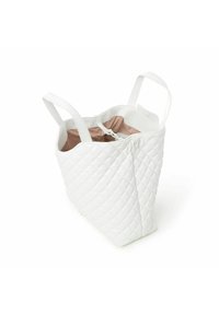 Sac fourre-tout synthétique matelassé blanc avec deux anses, doté d'un intérieur rose pâle et d'une fermeture éclair. Texture distinctive en motif de diamant.