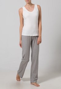 White cotton tank top with a V-neck, paired with light gray cotton pants featuring an elastic waistband and a loose fit.