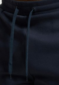 Sudadera de color azul marino con bolsillo tipo canguro, presenta cordones ajustables y ojales reforzados para mayor durabilidad.