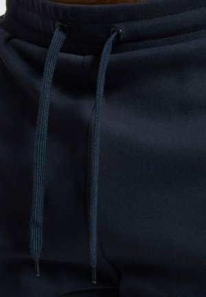 Sudadera de color azul marino con bolsillo tipo canguro, presenta cordones ajustables y ojales reforzados para mayor durabilidad.