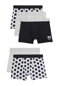 Conjunto de cuatro calzoncillos tipo boxer para niños: uno con un patrón hexagonal en blanco y negro, y tres en colores sólidos—negro, gris y gris oscuro—con cinturillas en contraste.