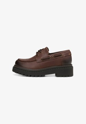 Braune Leder-Schnürschuhe mit runder Zehenform, dicker schwarzer Gummisohle, Metallösen und einer Nahtdetail entlang des Schaftes.