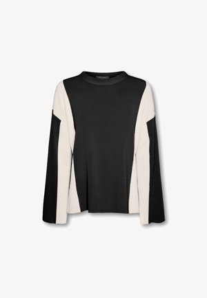 Suéter en bloques de color negro y crema con cuello alto y mangas largas. Material de punto suave, corte relajado y diseño angular único.