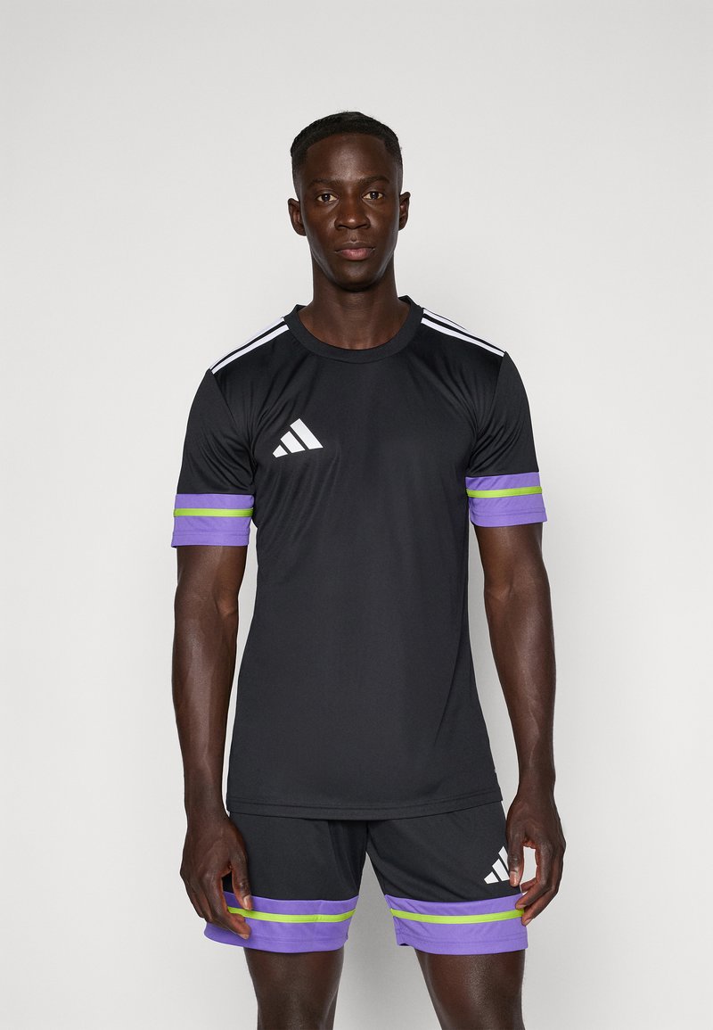 Zwart sportshirt met het witte Adidas-logo en drie witte strepen op de schouders; bijpassende zwarte shorts met paarse en groene strepen aan de zoom.