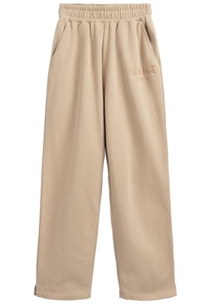 Beżowe dresy z elastycznym pasem, bocznymi kieszeniami i subtelnym logo „GANT” wyszytym na górnej części lewej nogawki.