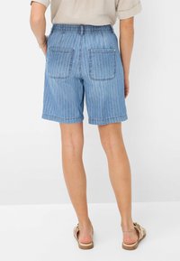 Shorts in denim con un motivo a righe blu, dotati di una vita elastica e due tasche posteriori. L'orlo si trova appena sopra il ginocchio.
