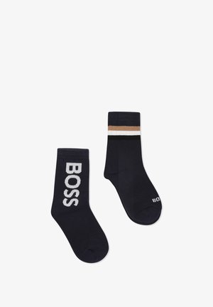 Chaussettes en mélange de coton bleu marine présentant un grand logo "BOSS" sur l'une et un haut rayé en beige, blanc et noir sur l'autre.