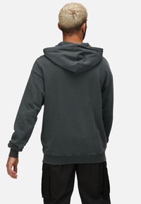 Mörkgrå hoodies med lös passform, med ribbade muddar och nederkant. Enkel design, mjuk textur, inga synliga mönster eller detaljer.