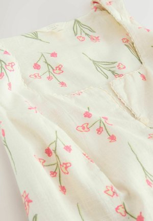 Weißes ärmelloses Leinenkleid mit rosa Blumenmuster und gewelltem Ausschnittdetail.