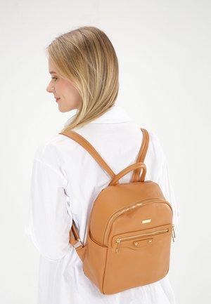 Brauner Leder-Rucksack mit glatter Textur, ausgestattet mit goldfarbenen Beschlägen, einer vorderen Reißverschlusstasche und zwei Schultergurten. Kompakte und strukturierte Gestaltung.