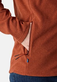 Pullover texture color ruggine con tasca laterale dotata di zip e cordino. Presenta una leggera elasticità e vestibilità casual.