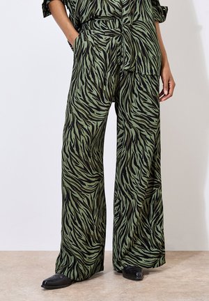Loose, wide-leg pants in green fabric featuring a black tiger stripe pattern. The material appears lightweight with a smooth texture.