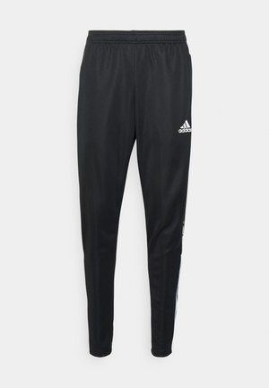 Czarne sportowe spodnie z elastycznym pasem, zwężanymi nogawkami, logo Adidas na górnej części uda oraz białe paski wzdłuż zewnętrznych szwów.