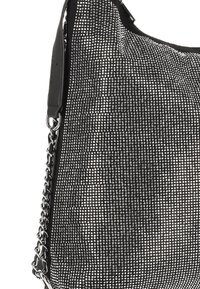Zwarte handtas met een gestructureerd oppervlak bedekt met kleine zilveren studs. Voorzien van een schouderriem gemaakt van ketting en lederen accenten.