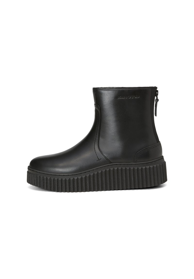 Bottines noires en cuir lisse avec une semelle plateforme épaisse et nervurée, et une fermeture éclair sur le côté. Design minimaliste, sans motifs visibles.