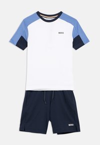 Λευκό T-shirt με κοντά μανίκια και μπλε και ναυτικές λεπτομέρειες, με το λογότυπο "BOSS". Συνδυασμένο με ναυτικό σορτς, επίσης με λογότυπο στο πλάι.