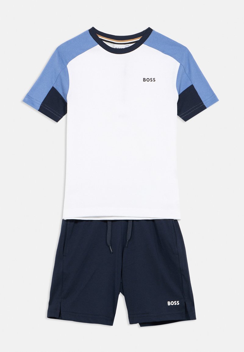 Maglietta bianca a maniche corte con accenti blu e navy, con logo "BOSS". Abbinata a pantaloncini navy, anch'essi con logo sul lato.