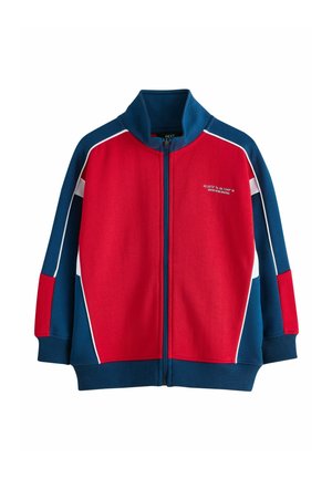 Laste lukuga jakk punase esiosaga, siniste varrukate ja kraega, valge ääristusega ning vasakul rinnal väikese valge kirjaga.