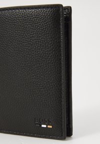Black leather wallet with textured surface. Features embossed logo and three color accents on the bottom. Slim design with clean lines.