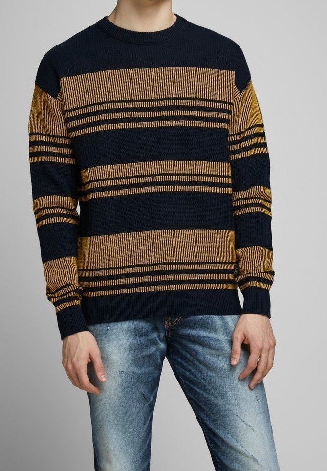 Marinblå och senapsgul randig stickad tröja med rund halsringning och ribbade ärmslut, ihop med ljusblå slitna jeans.