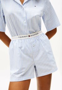 Light blue and white striped short pajama set with a collar, button front, and elastic waistband featuring "TOMMY HILFIGER" logo.