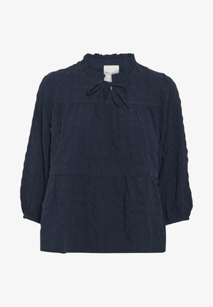 Tmavomodrá textúrovaná blúzka s volánikovým výstrihom, detailom na viazanie a dlhými rukávmi. Má voľný strih a výrobníkový dizajn.