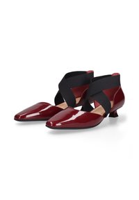 Bordeaux patent leren hakken met puntige neuzen, voorzien van zwarte elastische kruislussen rond de enkel en lage blokhakken.