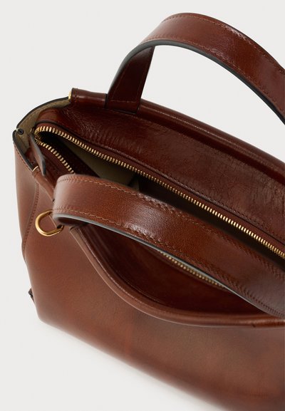 Καφέ δερμάτινη τσάντα χειρός με φερμουάρ, που διαθέτει ομαλή υφή και χρυσά μεταλλικά στοιχεία. Ισχυρές, κοντές λαβές για εύκολη μεταφορά.