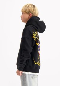 Zwarte hoodie van katoen, met een kleurrijk grafisch ontwerp in geel en blauw. Geknipt met een ontspannen pasvorm en een grote capuchon.