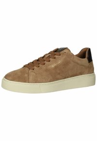 Braune Wildledersneaker mit niedrigem Profil, runder Zehenform, Schnürung vorne und einem kontrastierenden dunklen Fersenelement. Weiße Gummisohle und dezentes Logodetail.