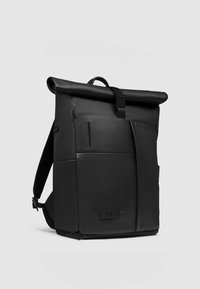 Zwarte roll-top rugzak van getextureerd leer met verstelbare banden, een voorvak met rits en een minimalistisch ontwerp.