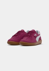 Maroon mokasine od suede materijala s bijelim detaljima, s gumeni potplat i vezanjem. Uključuje detalj s logotipom sa strane.