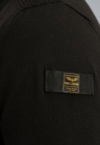 Čierny pletený sveter s textúrovaným povrchom, ktorý má obdĺžnikový tkaný štítok v čiernej a zlatej farbe s brandingom "PME Legend".